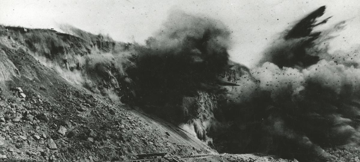 historical image of blasting of hillside with explosives