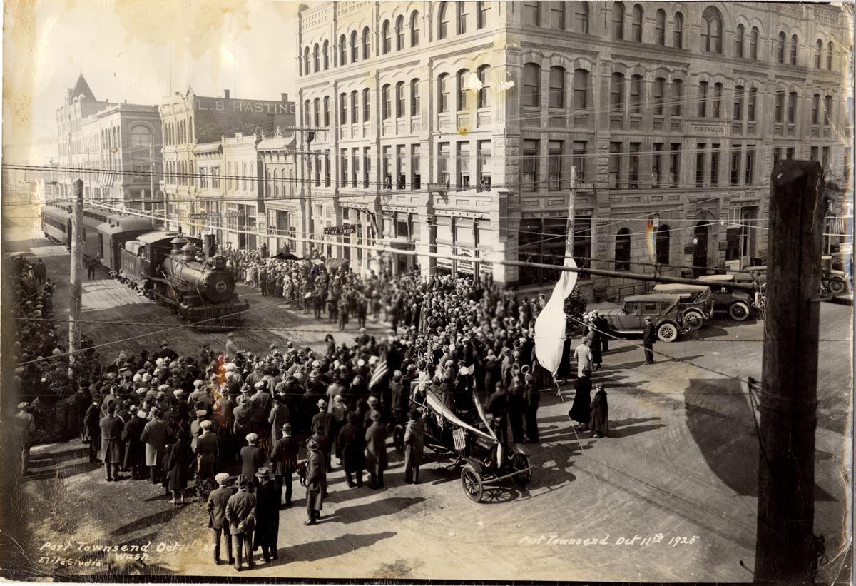historical image of a crowd of people standing near a train in downtown Port Townsend