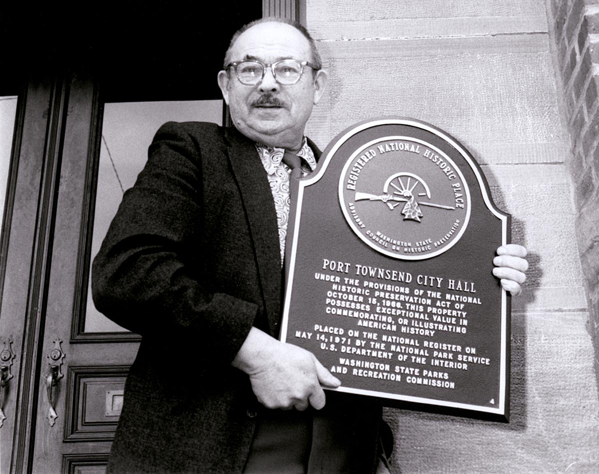 historical image of man holding a large plaque