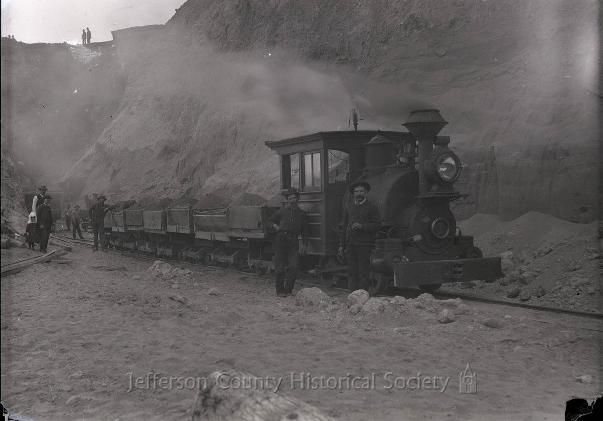 historical image of steam engine helping to excavate a hillside